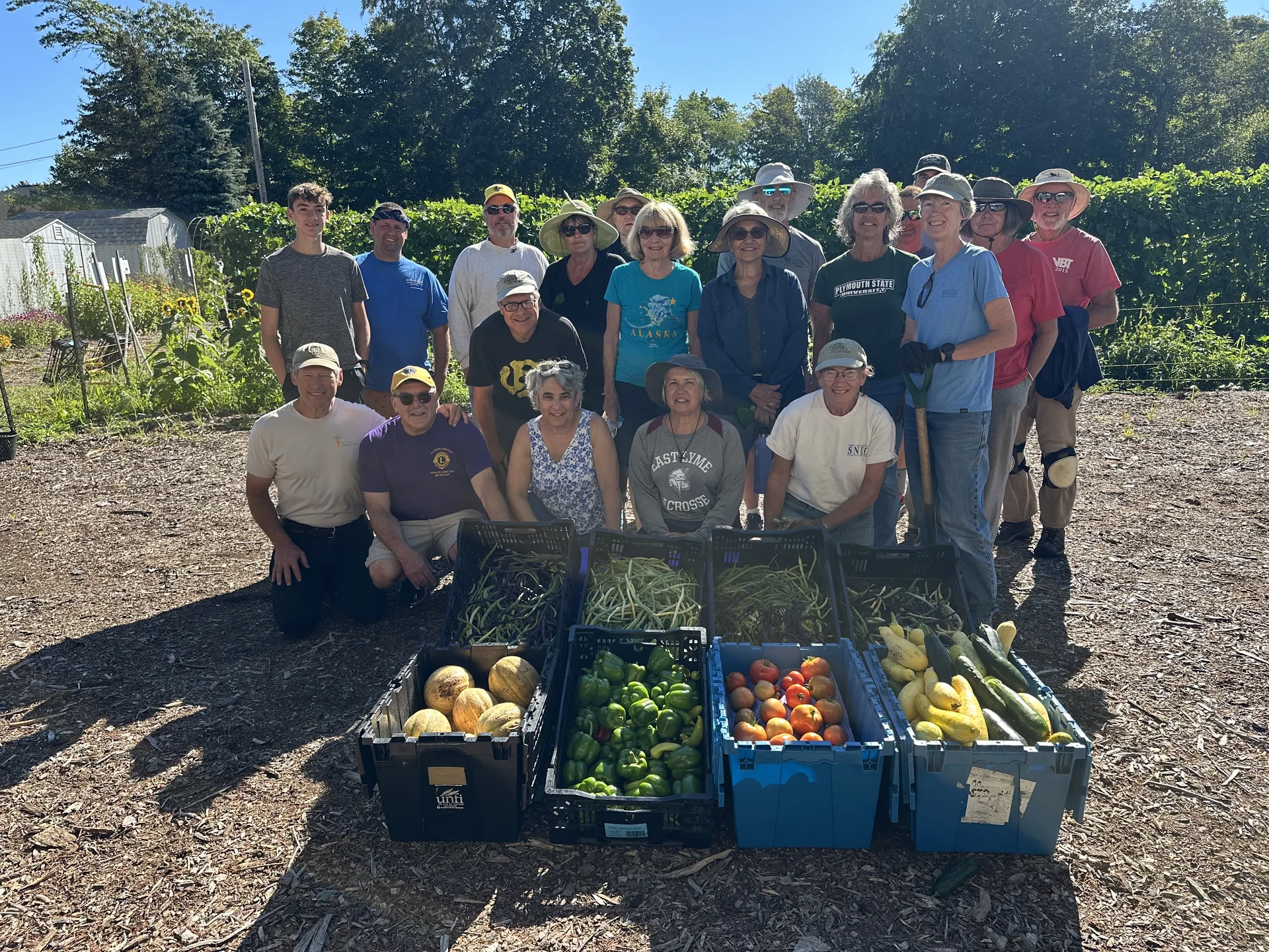 East Lyme Giving Garden volunteers gathered behind crates of freshly harvested vegetables